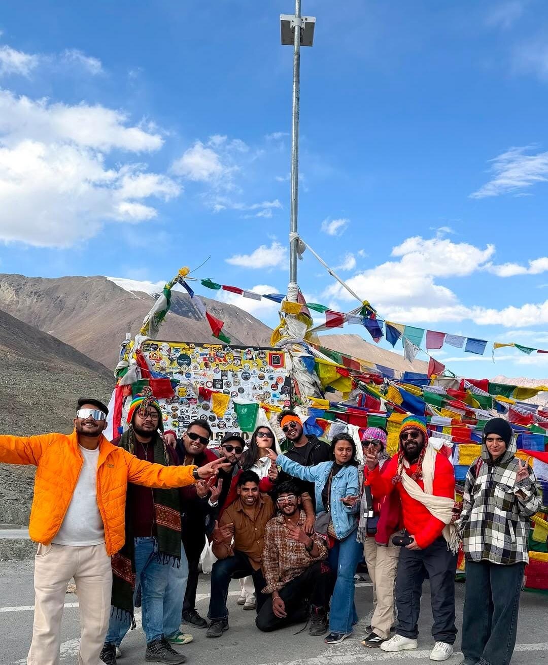 TRAVIA group sharing a moment beneath colorful mountain prayer flags